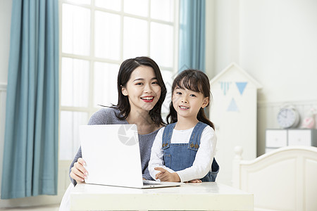 妈妈陪着女儿用笔记本电脑上网课图片