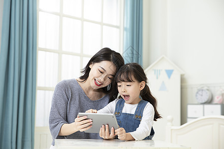 妈妈陪伴女儿平板电脑在家上课图片