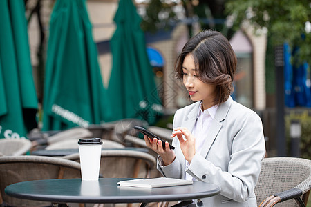 商务职业女性在户外看手机图片