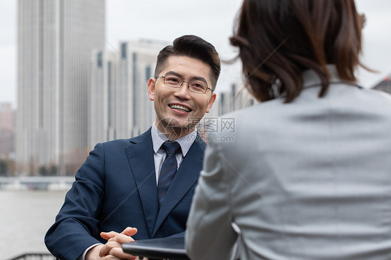 商务男士与商业伙伴洽谈工作图片