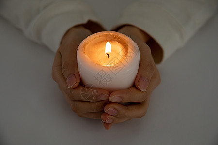 双手捧蜡烛祈福特写图片素材