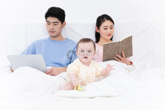 爸爸看电脑妈妈看书婴儿自己玩闹图片