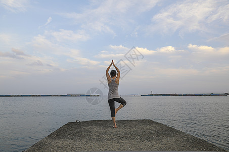 在海边练习瑜伽的女人背影图片