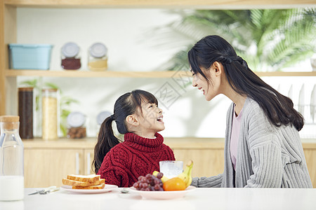 年轻妈妈和女儿吃早餐互动背景