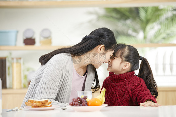 年轻妈妈和女儿吃早餐互动图片