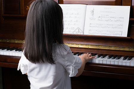 小女孩弹琴认真弹钢琴的女孩背景