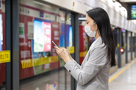 戴口罩的女性拿手机等地铁高清图片