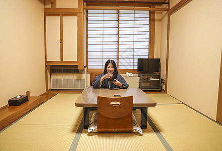 在日式旅馆房间喝日式茶的女人图片