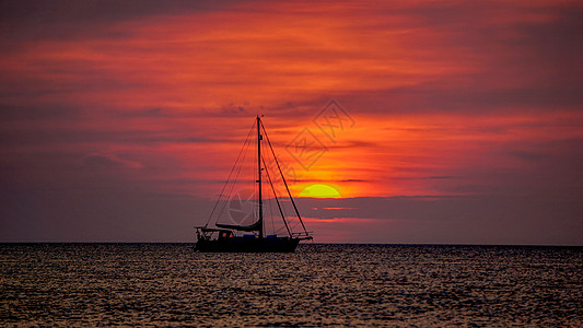 日落黄昏时海面上的帆船背景
