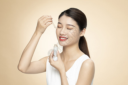 青年女性美容护肤涂抹精华液图片素材