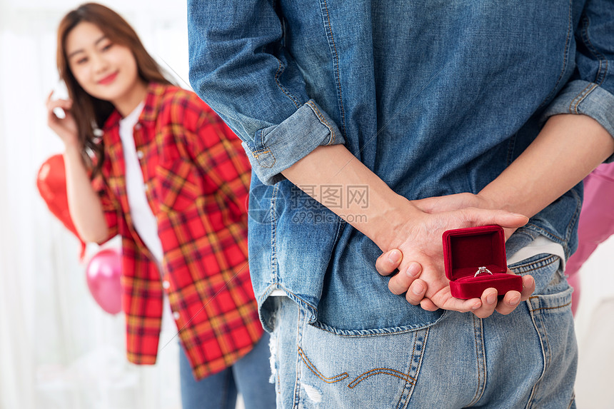 青年男性拿钻戒向女朋友求婚图片