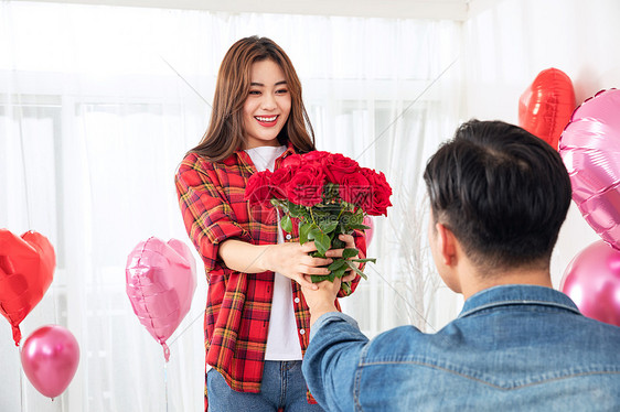 男性拿玫瑰花向女朋友求婚图片