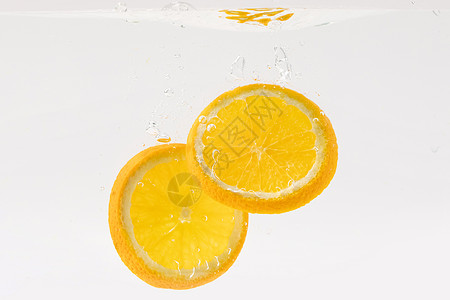 创意水果掉落水中的橙子水果切片背景