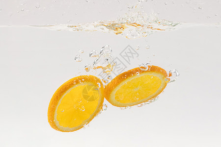 掉落水中的橙子水果切片图片