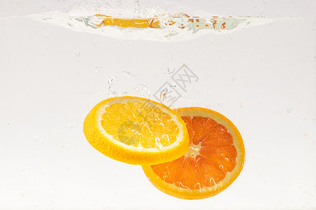 创意水果掉落水中的橙子水果切片背景