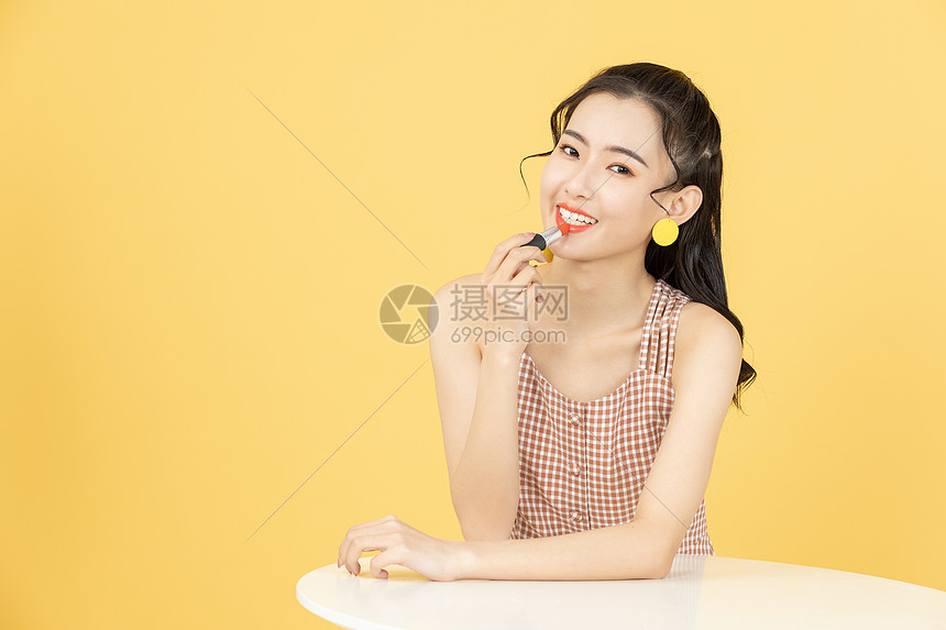 涂抹口红的甜美女性图片