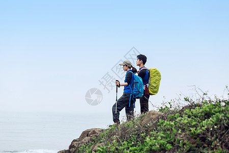 出游季郊外站山坡上背包的男女青年背景