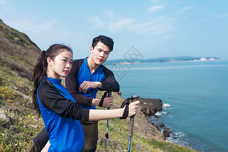 野外海边山坡徒步中休息的男女图片