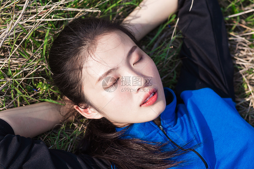 户外睡在草地上休息的女生图片
