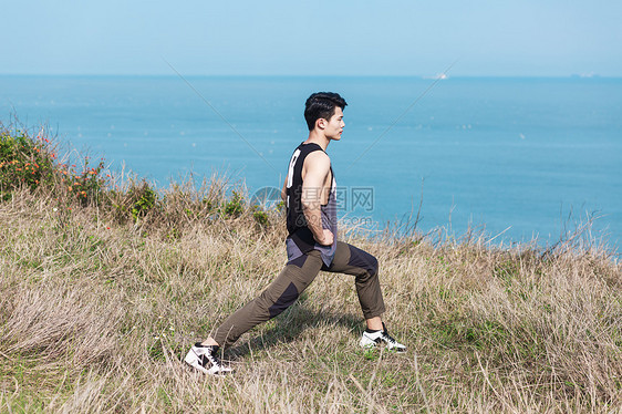 户外海边草坪上热身男性图片