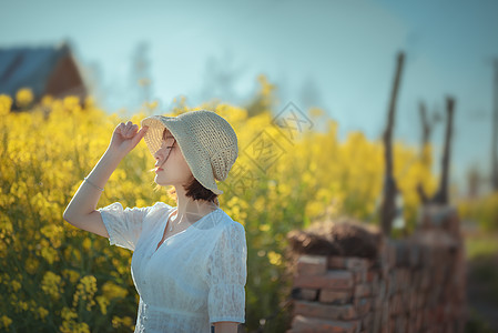 唯美油菜花踏青戴草帽美女图片