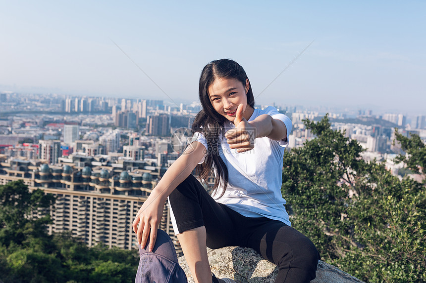 户外坐石头上点赞美女人像图片