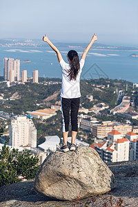 厦门城市公园山顶站石头上举起双臂欢呼的美女图片