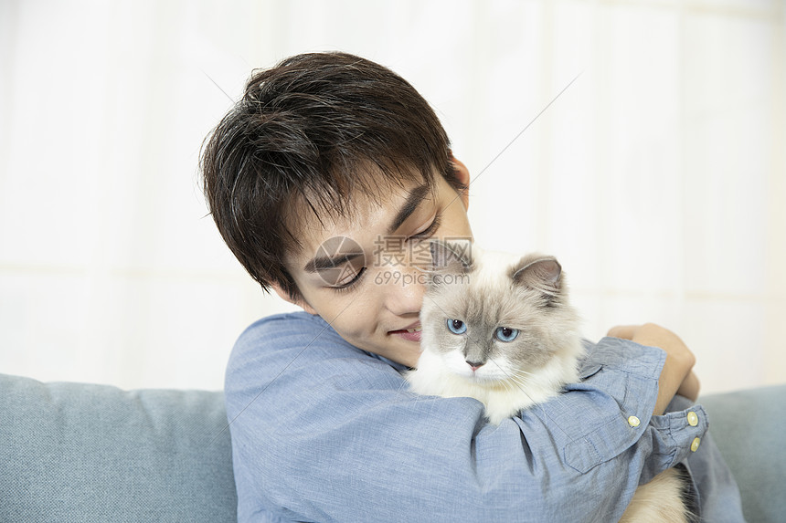 抱着宠物猫的居家男孩图片