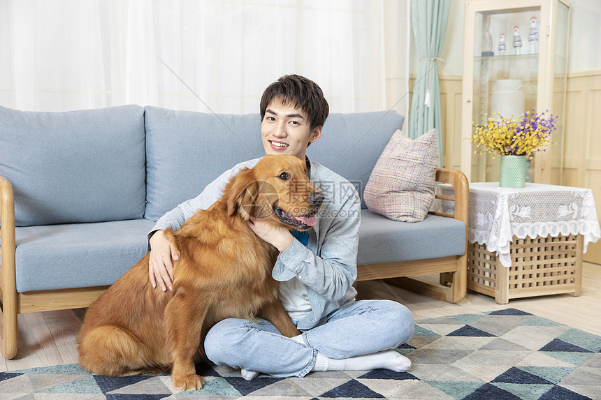 与金毛相伴的居家男孩图片