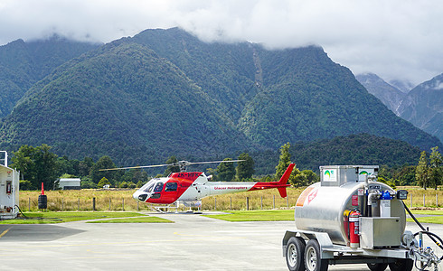 私人直升机高山下停机坪上的直升机背景