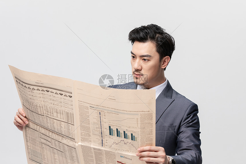 商务男性看报纸特写图片