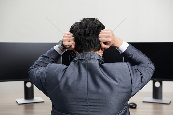 商务男性电脑桌前头疼背影图片