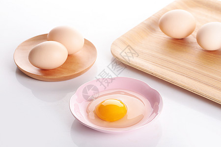 盛放在托盘上的鸡蛋和盛放在盘子里的蛋黄蛋清高清图片