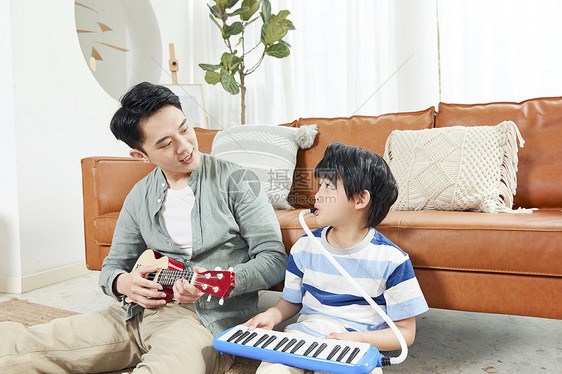 父亲和孩子在家一起玩乐器图片