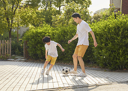 爸爸和儿子父亲陪孩子一起踢足球背景