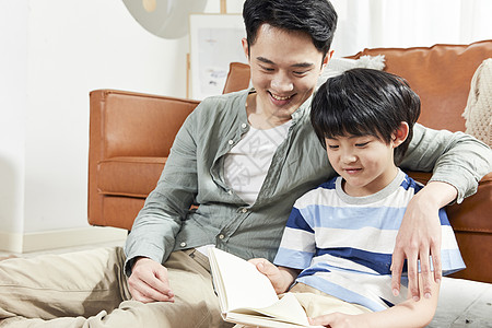 父子看书年轻爸爸陪儿子读书背景