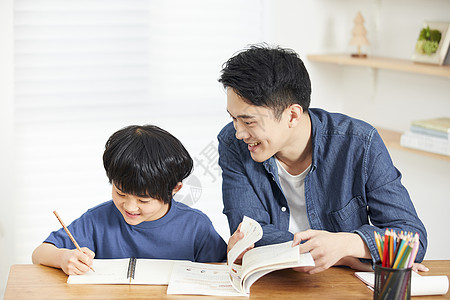 家庭辅导年轻爸爸辅导儿子写作业背景