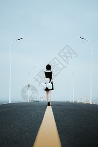 孤单道路上的一个女性背影图片