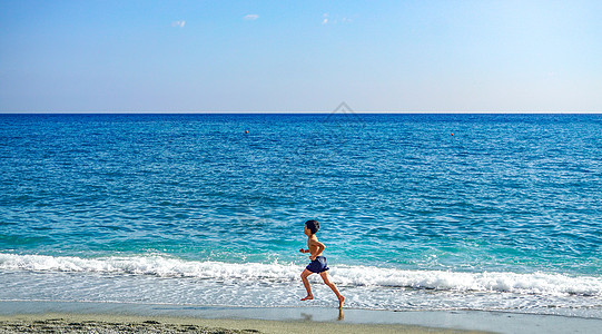 海边奔跑的小男孩背景图片