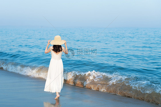 海边沙滩散步的美女背影图片