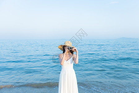 长头发女生拍照摄影的海边女生背景