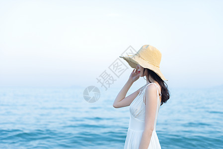 海边戴草帽的女生侧影图片