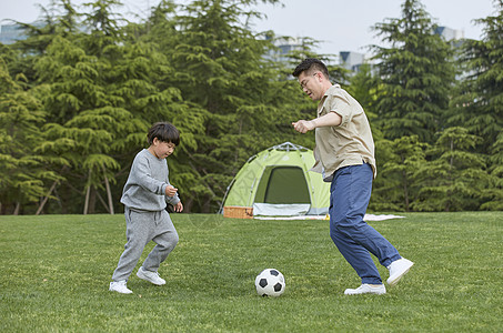 中国城墙草坪上踢足球的父子背景