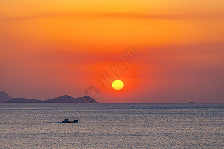 红彤彤的天空海上日出安静的海和渔船背景