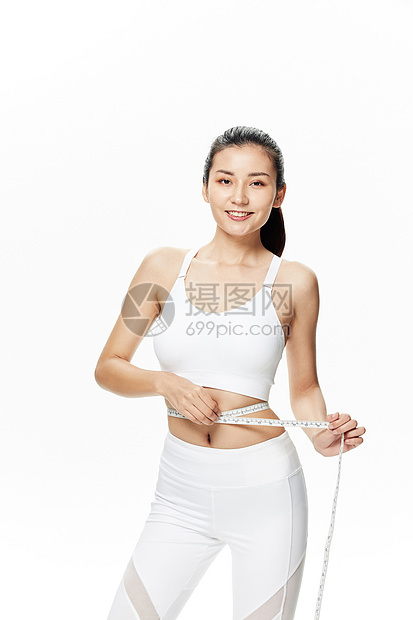 运动美女用皮尺测量腰围图片