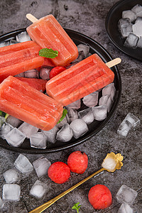 西瓜与冰棒西瓜味的冰棒放置在冰块上背景