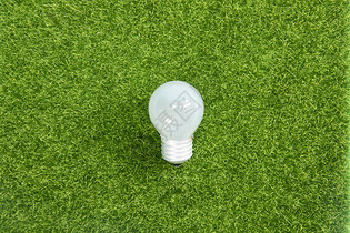 节能灯泡与绿色草坪图片