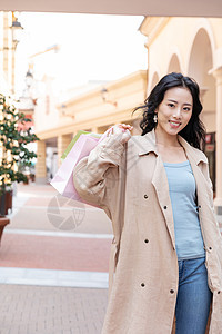 户外手提购物袋逛街的青年女性图片