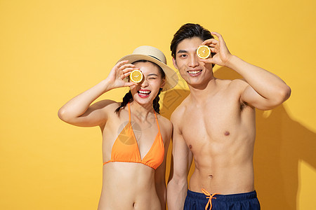 夏日泳装情侣拿着柠檬背景图片