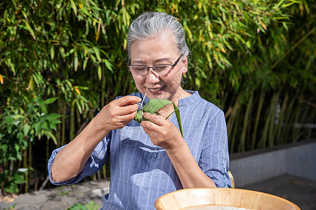 端午节户外奶奶包粽子图片